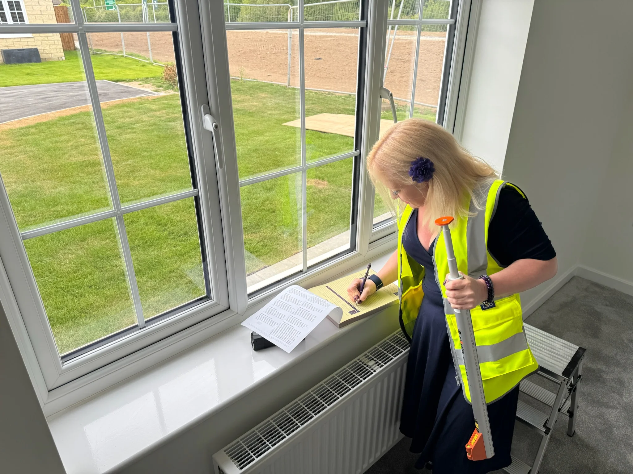 Ria from Ria's Interiors measuring a window and taking notes during a home consultation