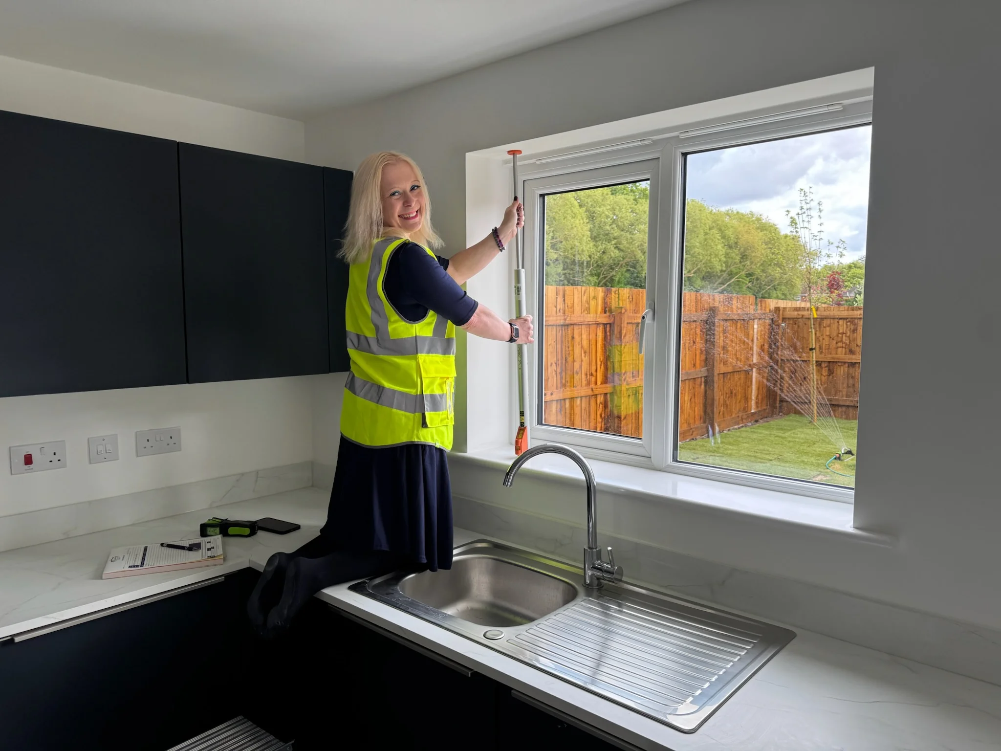 Ria from Ria's Interiors measuring a kitchen window during a home consultation