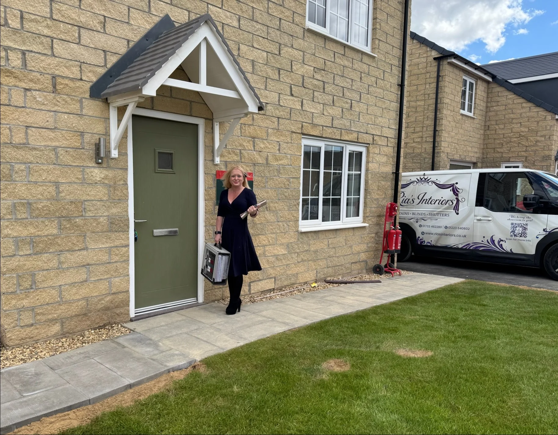 Ria from Ria's Interiors outside a new build home with sample case and branded van