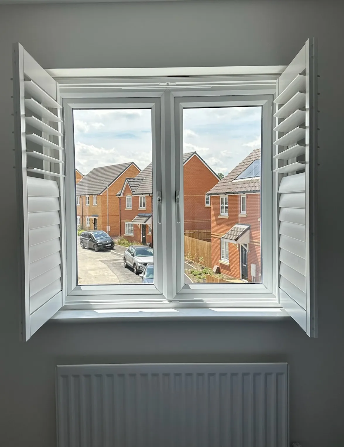 Both shutter panels swung open at an upstairs window