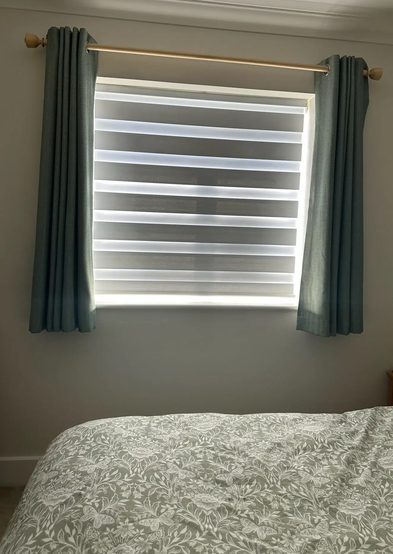 Day and night blinds with curtains fitted in a bedroom by Ria’s Interiors
