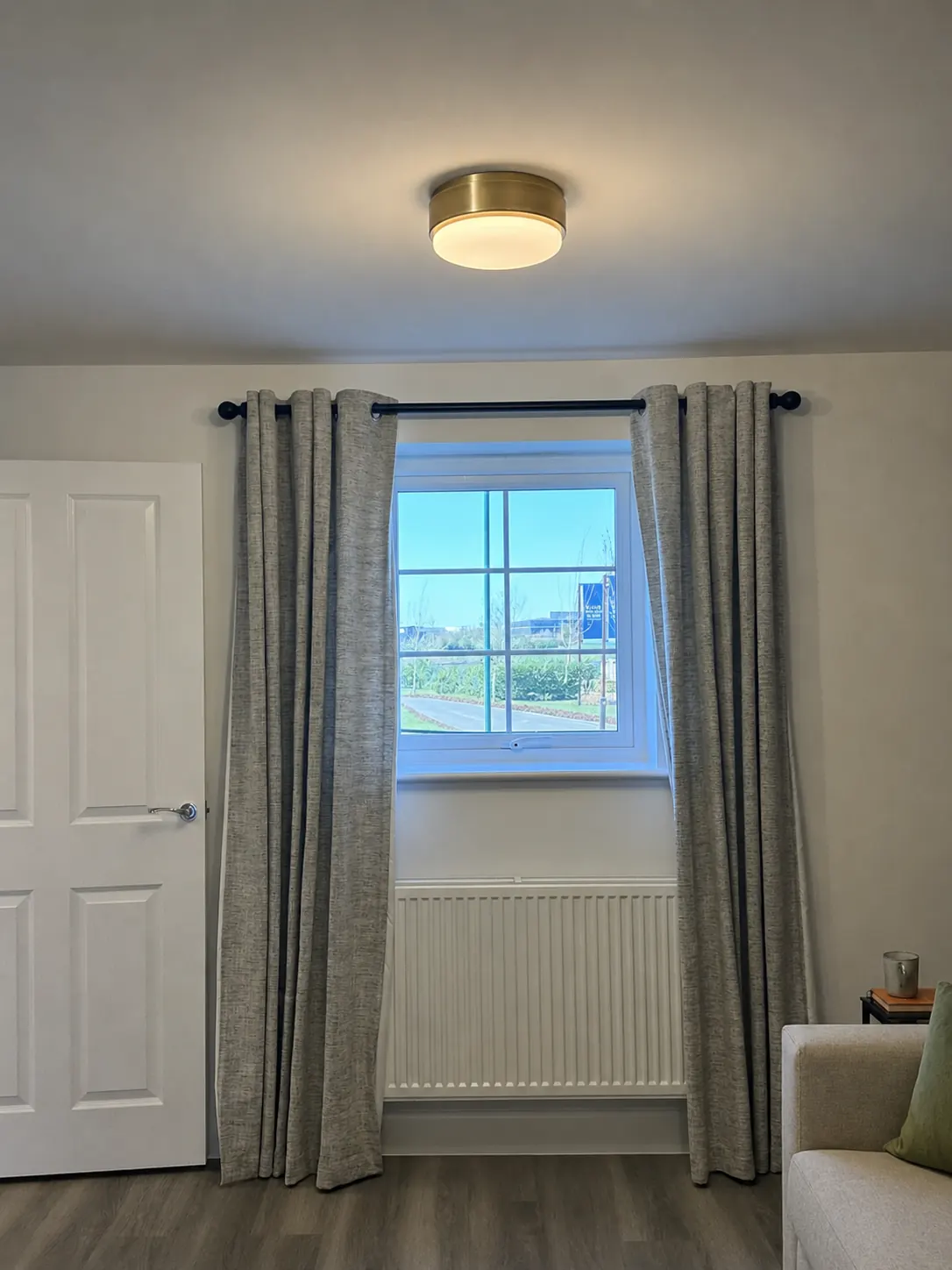 Grey textured eyelet curtains fitted around a bedroom window