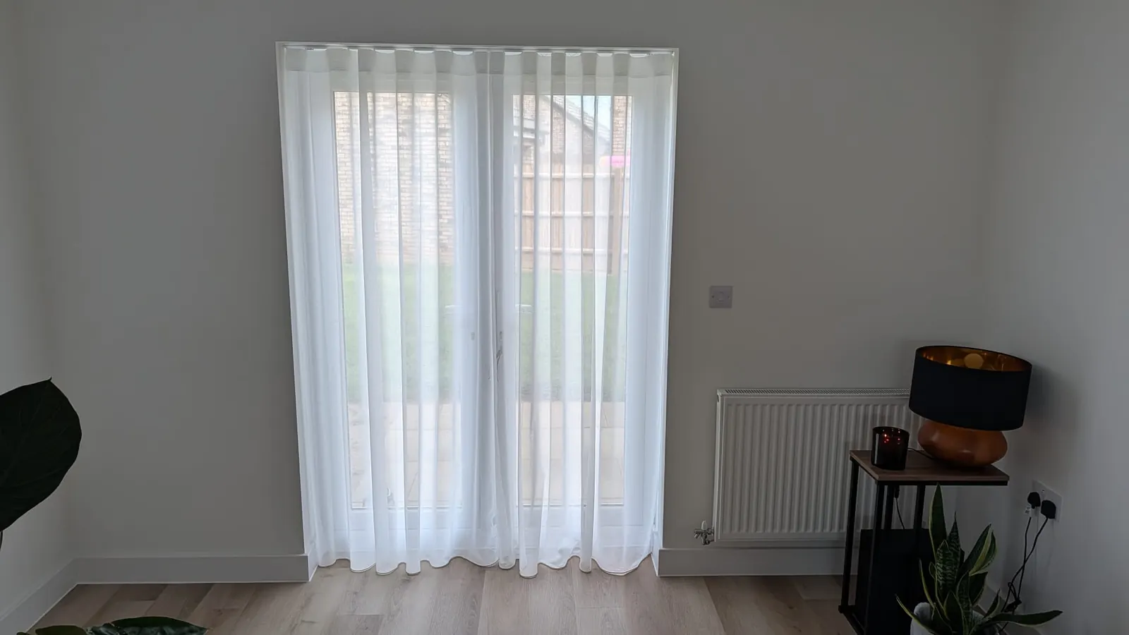 Wave-heading sheer curtains fitted across French doors