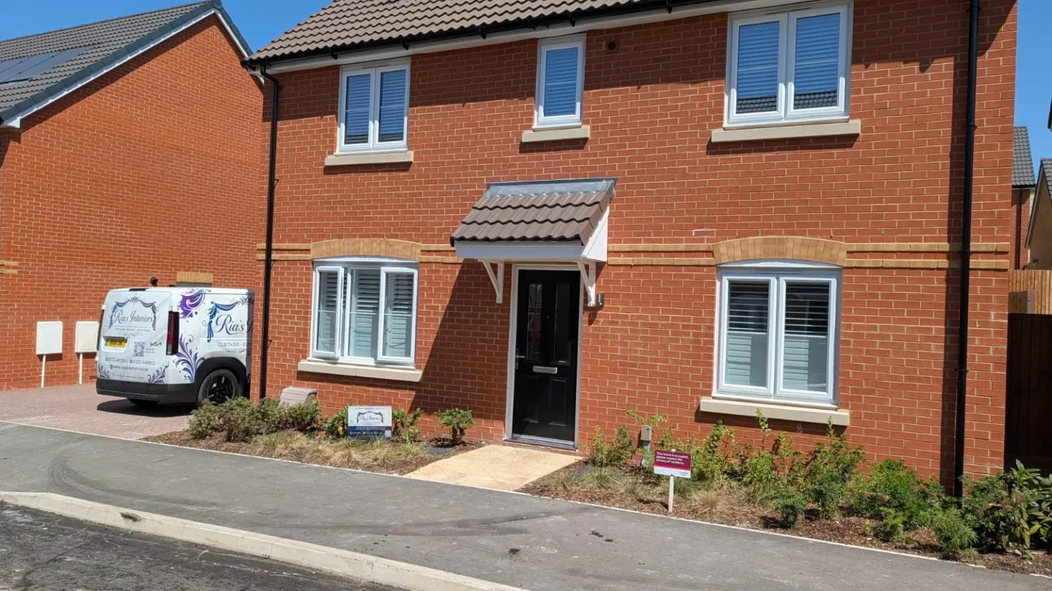 Ria's Interiors van outside a new-build home fitted with white shutters