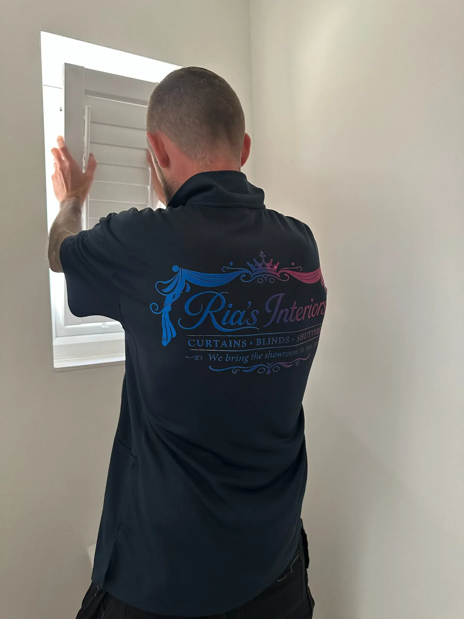 Ria's Interiors fitter carefully adjusting a newly fitted shutter panel