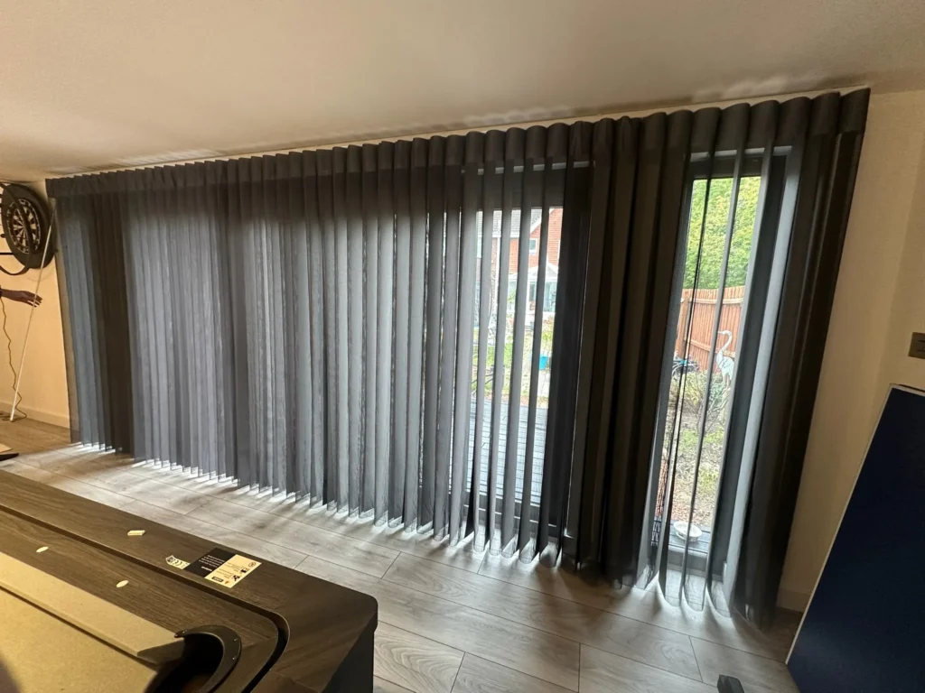Grey Allusion blinds, with sheer and solid fabric panels, drawn across wide garden doors