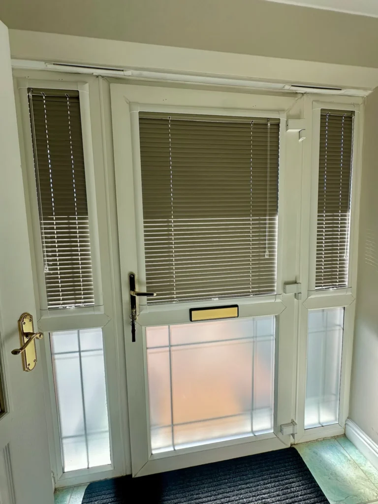 White Perfect Fit Venetian blinds fitted to the glazed panels of a front door and side panels