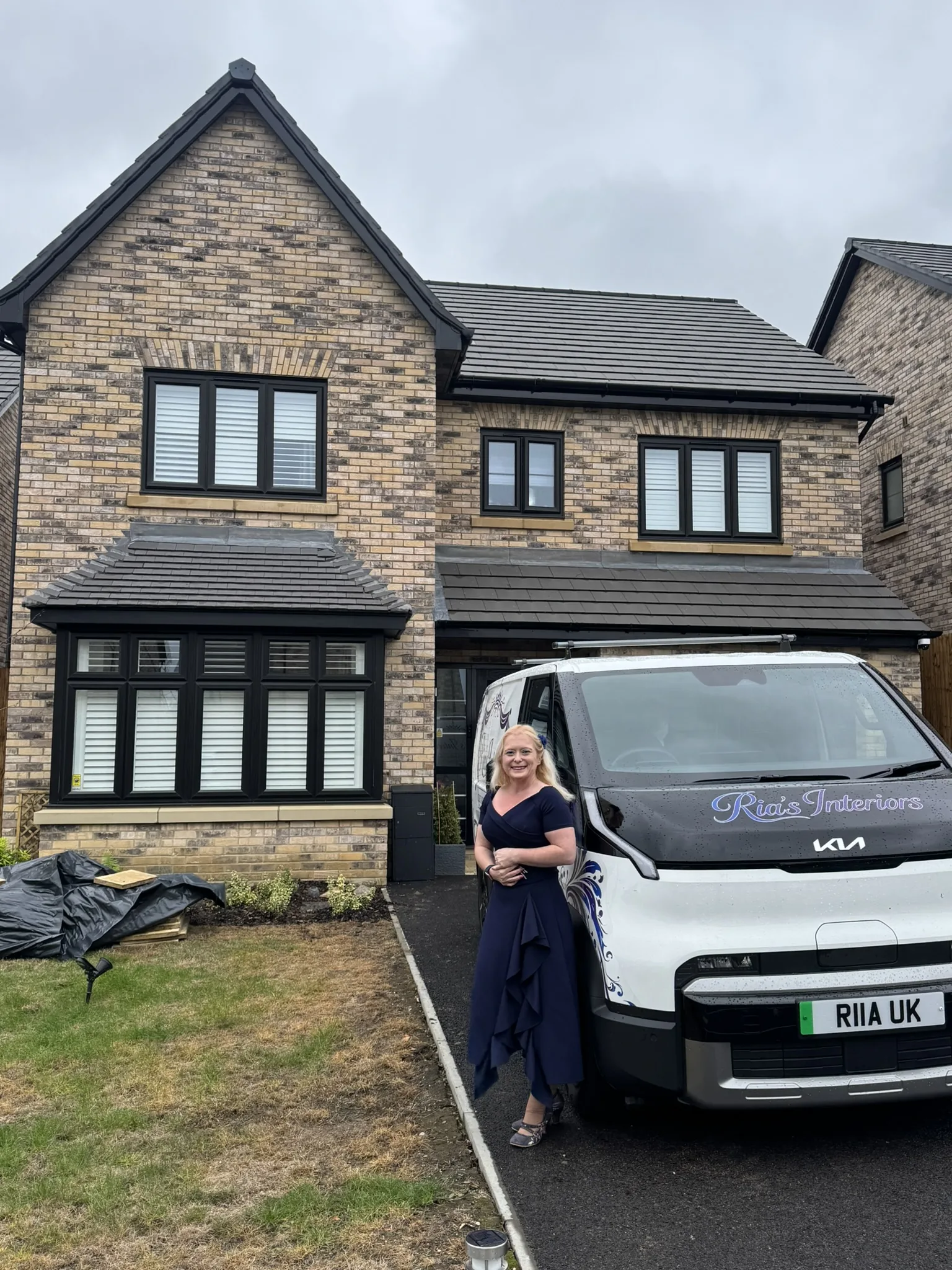 Ria beside the Ria&rsquo;s Interiors van outside a new-build home fitted with white UK-made shutters